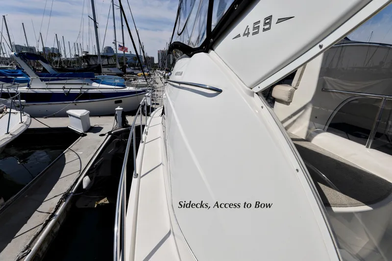 Slide: The Image of 2005 Meridian 459 Aft Cabin Motor Yacht side view at marina, showcasing side deck access. - 13