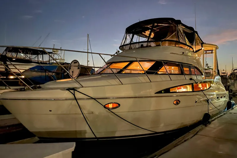 Slide: The Image of 2005 Meridian 459 Aft Cabin Motor Yacht docked at sunset, illuminated interior. - 31