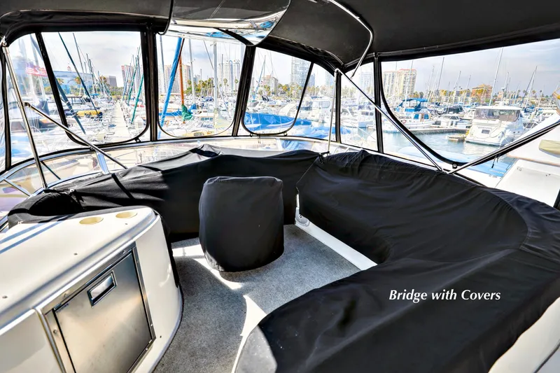 Slide: The Image of 2005 Meridian 459 Aft Cabin Motor Yacht bridge with protective covers in marina setting. - 9