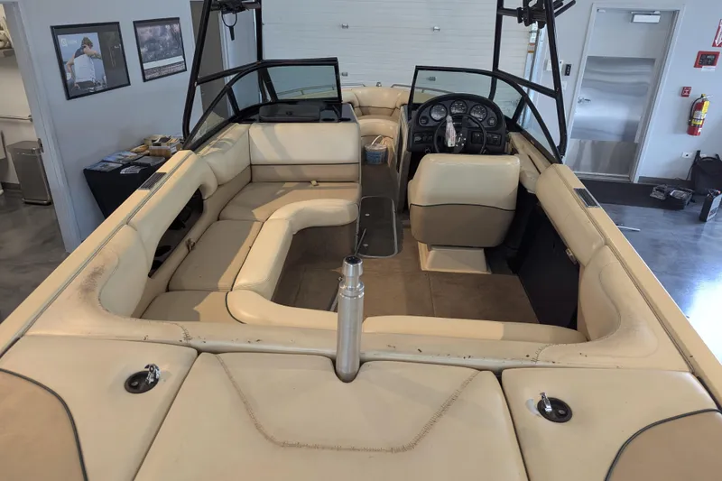 Slide: The Image of Interior of a 2000 Malibu Sunsetter VLX boat with beige seating and dashboard. - 10