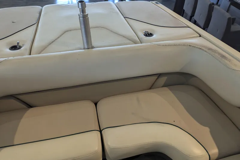 Slide: The Image of 2000 Malibu Sunsetter VLX boat interior with white cushioned seating and metal pole. - 12
