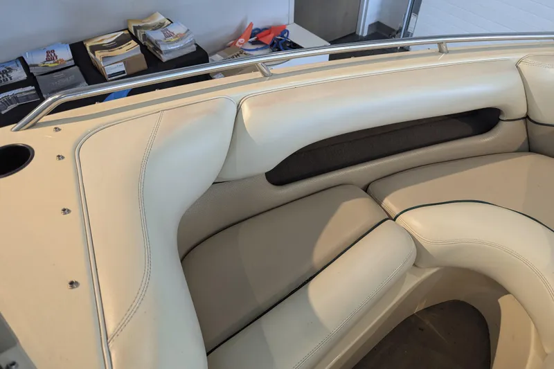 Slide: The Image of Interior seating of a 2000 Malibu Sunsetter VLX boat, featuring cream upholstery. - 15