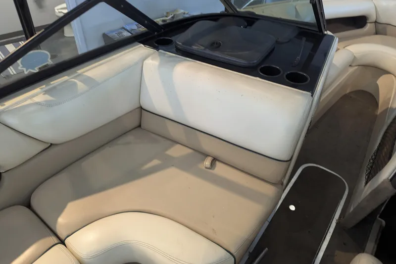 Slide: The Image of Interior of a 2000 Malibu Sunsetter VLX boat with beige seating and cup holders. - 18