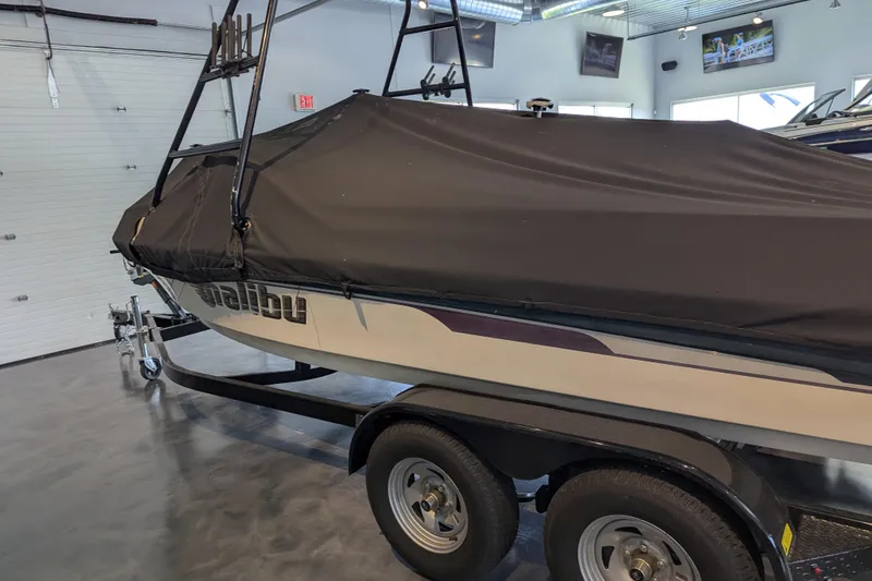 Slide: The Image of 2000 Malibu Sunsetter VLX boat with cover on trailer in showroom. - 24
