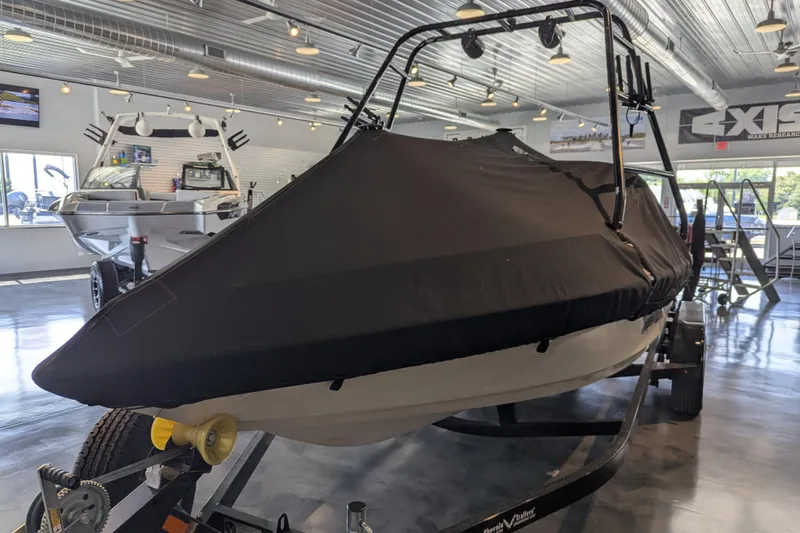 Slide: The Image of 2000 Malibu Sunsetter VLX boat covered in black tarp inside a showroom. - 26