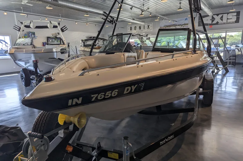 Slide: The Image of 2000 Malibu Sunsetter VLX boat displayed in a showroom with other boats. - 7