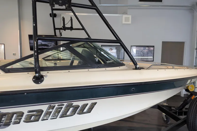 Slide: The Image of 2000 Malibu Sunsetter VLX boat in showroom, featuring sleek design and sturdy frame. - 8