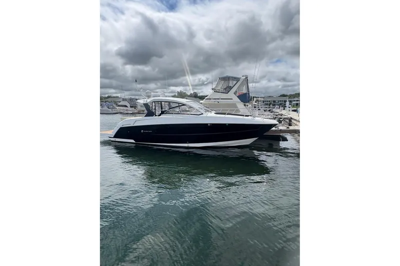 The Image of 2017 Cruisers Yachts 39 Express Coupe on water, cloudy sky background. - 0