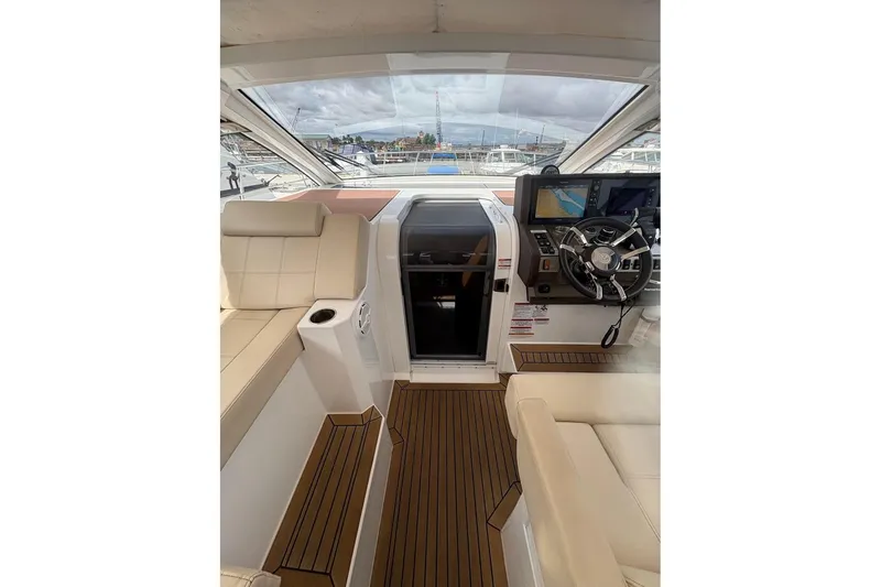 Slide: The Image of 2017 Cruisers Yachts 39 Express Coupe interior with beige seating and "Captain" pillow. - 19