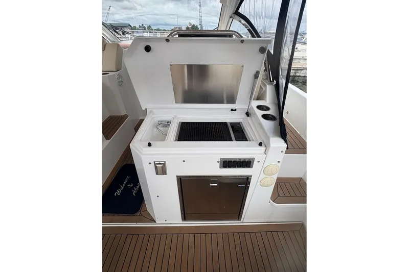 Slide: The Image of 2017 Cruisers Yachts 39 Express Coupe interior with seating and table, docked at marina. - 17