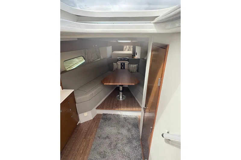 Slide: The Image of Interior of 2017 Cruisers Yachts 39 Express Coupe, featuring a cozy dining area and wooden finishes. - 28