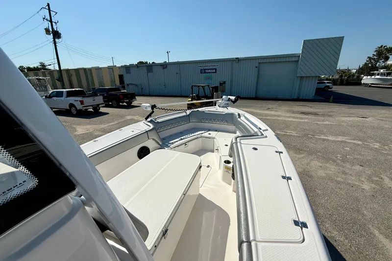 Slide: The Image of 2022 Blue Wave 2800 Makaira boat, docked in a marina, showcasing spacious deck and seating. - 13