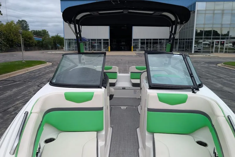 Slide: The Image of 2018 Chaparral Vortex 203 VRX boat with green and white interior, parked outdoors. - 11