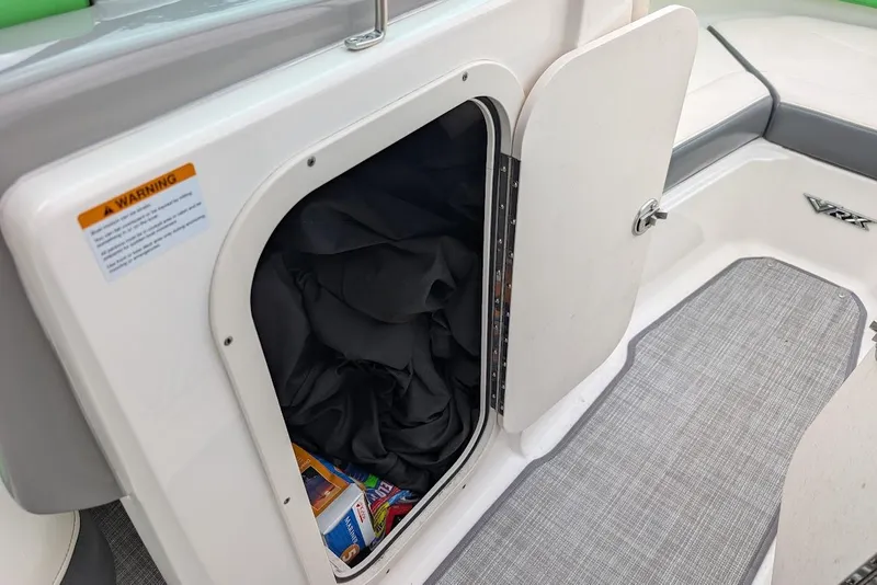 Slide: The Image of Storage compartment in 2018 Chaparral Vortex 203 VRX boat, open with items inside. - 14