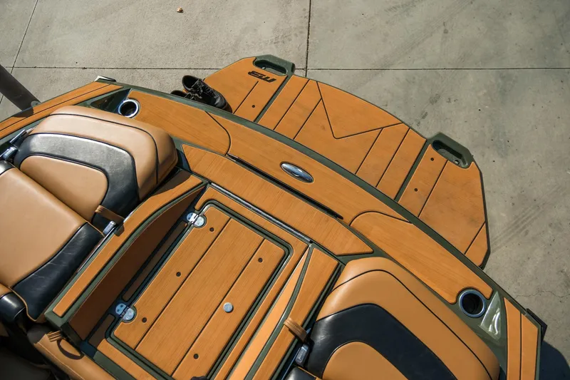 Slide: The Image of 2022 MB B52 23 Alpha boat interior with tan and black seating, wooden deck. - 19