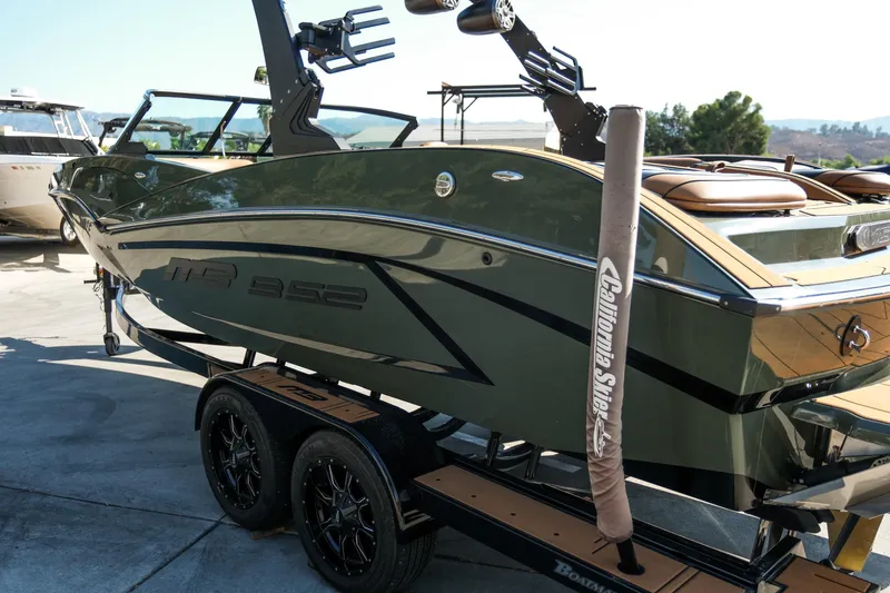 Slide: The Image of 2022 MB B52 23 Alpha boat on trailer, sleek design, parked outdoors. - 21