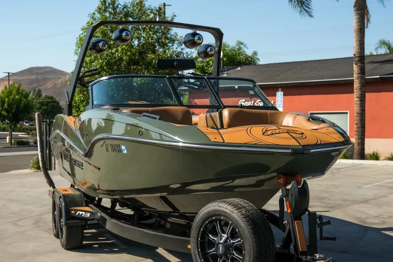 Slide: The Image of 2022 MB B52 23 Alpha boat on trailer, parked outdoors, showcasing sleek design. - 4