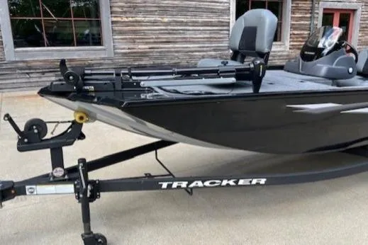 Slide: The Image of 2025 Tracker PRO170 boat on trailer, parked near rustic building. - 5