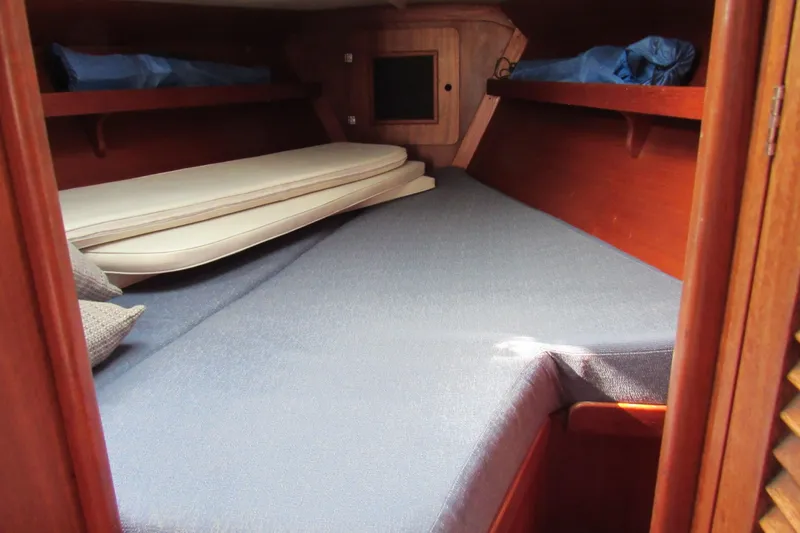 Slide: The Image of Cozy cabin interior of a 1976 Tartan 3800 sailboat with blue bedding. - 11