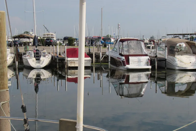 Slide: The Image of Boats docked at a marina, including a 1976 Tartan 3800, reflecting on calm water. - 15