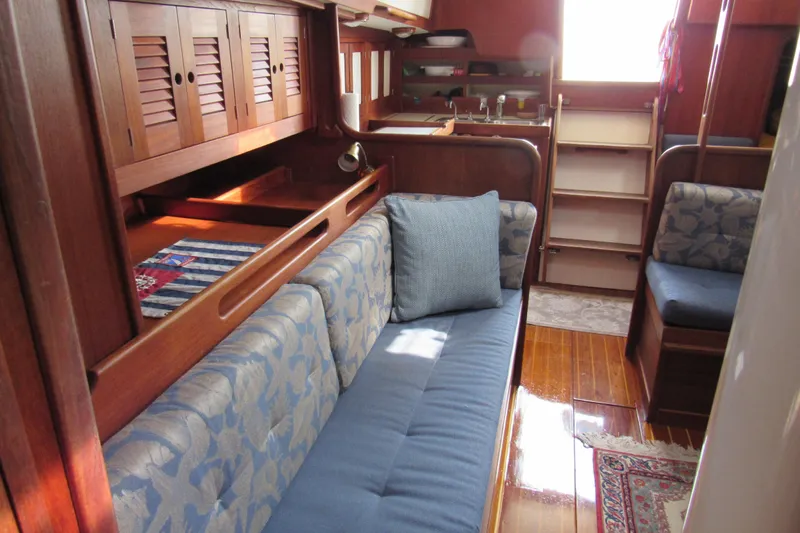 Slide: The Image of Interior of a 1976 Tartan 3800 sailboat with cozy seating and wooden cabinetry. - 6