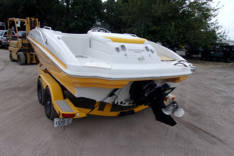 Slide: The Image of 2009 Tahoe 195 I/O boat on trailer, yellow and white, parked outdoors. - 3
