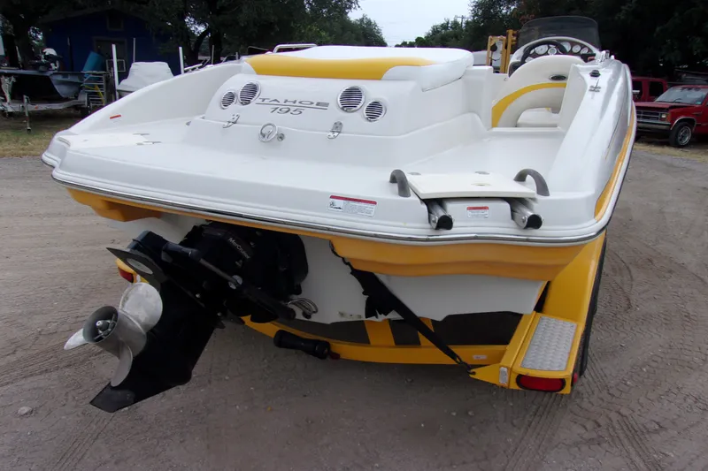 Slide: The Image of 2009 Tahoe 195 I/O boat, yellow and white, rear view with propeller, parked on dirt. - 4