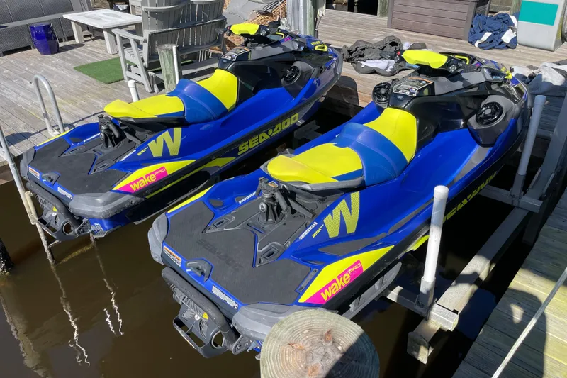 Slide: The Image of Two 2020 Sea-Doo Wake Pro 230 jet skis docked on a wooden pier. - 3
