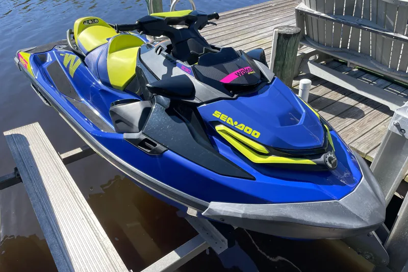 Slide: The Image of 2020 Sea-Doo Wake Pro 230 jet ski docked, featuring vibrant blue and yellow design. - 4