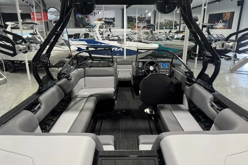 Slide: The Image of 2026 Moomba Max boat interior with sleek seating and modern dashboard in showroom. - 13