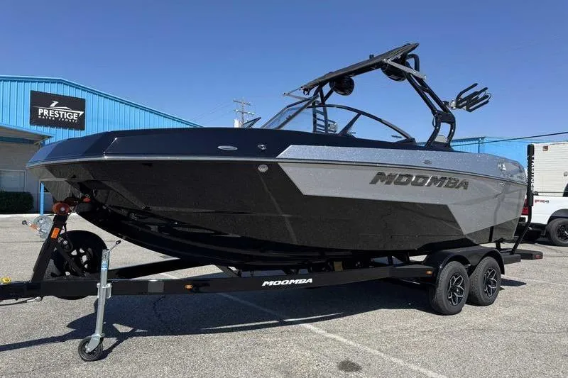 Slide: The Image of 2026 Moomba Max boat on trailer, parked outdoors near a blue building. - 15