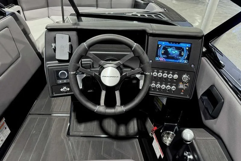 Slide: The Image of 2026 Moomba Max boat dashboard with steering wheel and digital display. - 7