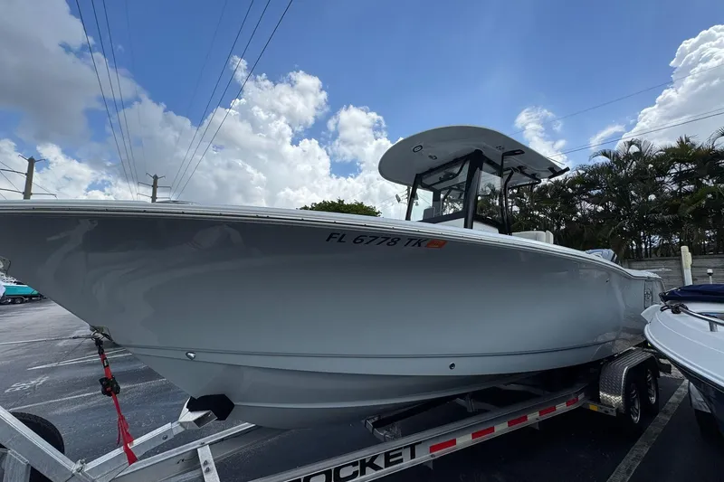 Slide: The Image of 2023 Sea Hunt Gamefish 27 Forward Seating boat on trailer under cloudy sky. - 1