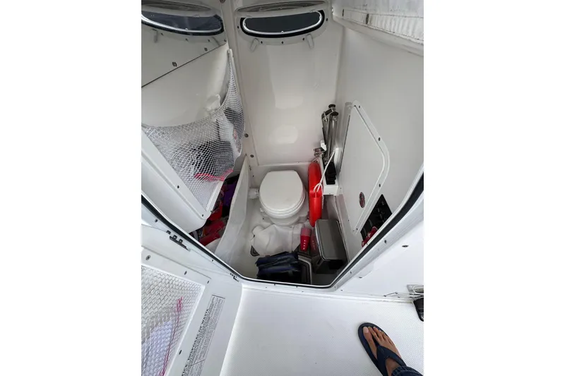 Slide: The Image of 2023 Sea Hunt Gamefish 27 boat interior with compact marine toilet and storage. - 11