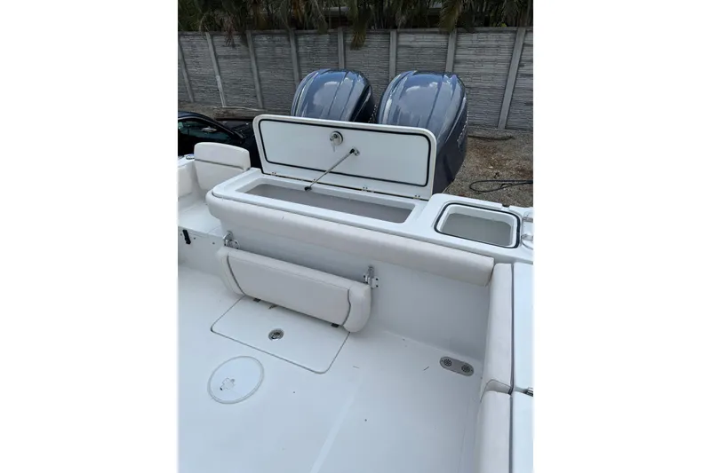 Slide: The Image of 2023 Sea Hunt Gamefish 27 boat with open storage compartment and dual engines. - 12