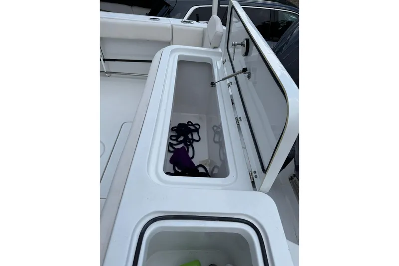 Slide: The Image of 2023 Sea Hunt Gamefish 27 storage compartment with open lid, showcasing interior space. - 13