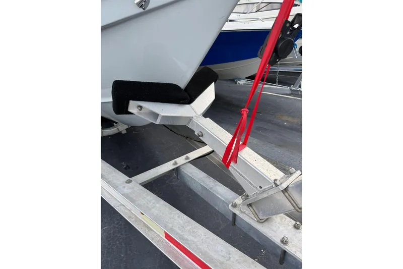 Slide: The Image of 2023 Sea Hunt Gamefish 27 boat on trailer with red strap. - 23