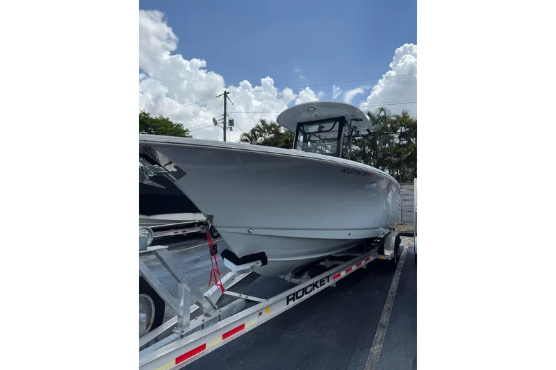Slide: The Image of 2023 Sea Hunt Gamefish 27 boat on trailer under blue sky. - 4
