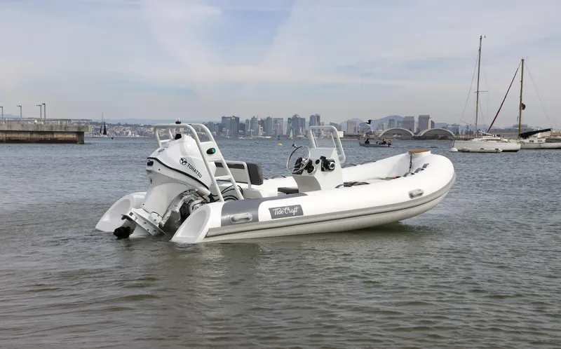 Slide: The Image of 2025 Tide Craft Catalina 13 boat on calm water with city skyline in background. - 2