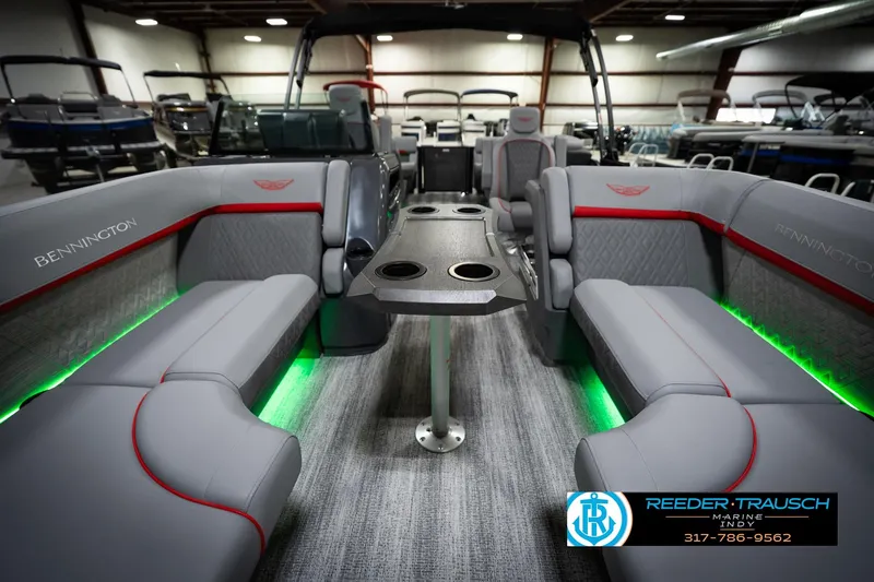 Slide: The Image of 2026 Bennington 22 MFB boat interior with gray seating, green LED lighting, and cup holders. - 15