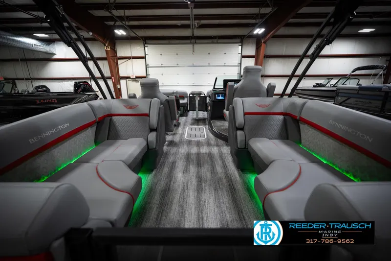 Slide: The Image of 2026 Bennington 22 MFB boat interior with gray seating and green LED lighting. - 18