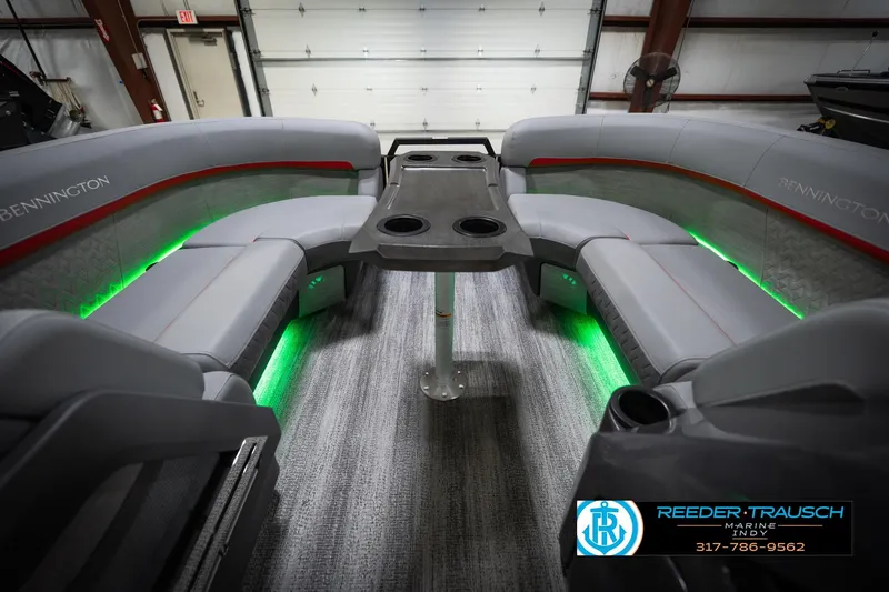 Slide: The Image of 2026 Bennington 22 MFB boat interior with gray seating, green LED lighting, and central table. - 20