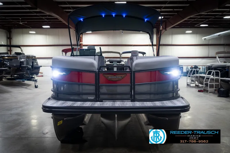 Slide: The Image of 2026 Bennington 22 MFB pontoon boat in showroom with illuminated lights. - 4