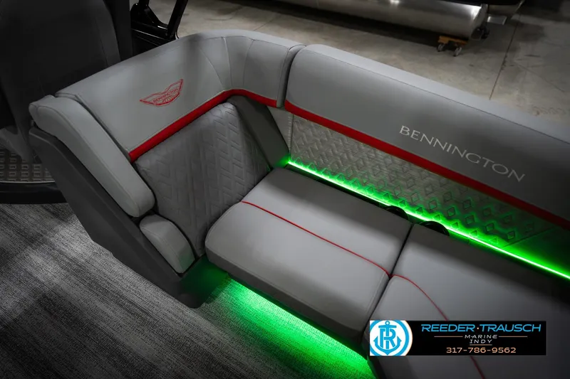 Slide: The Image of 2026 Bennington 22 MFB boat interior with gray seating, red accents, and green LED lighting. - 41