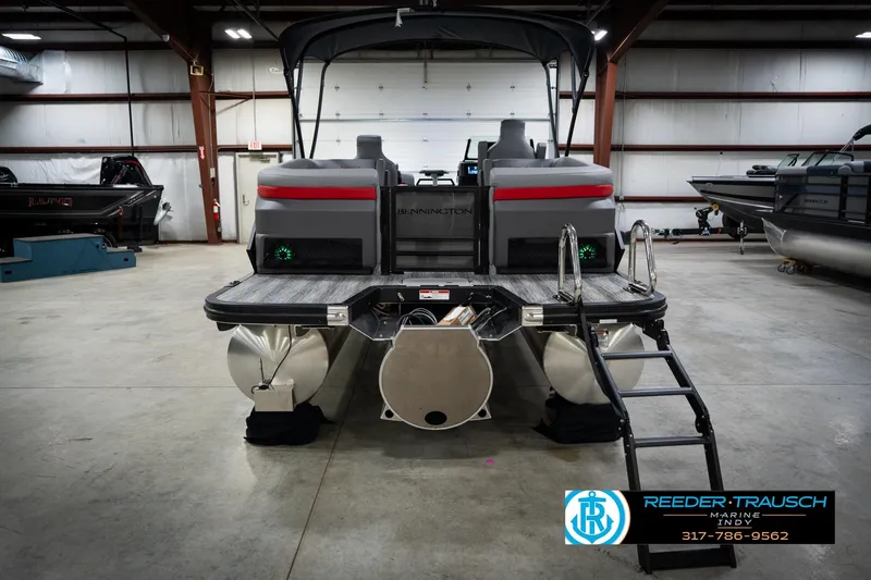 Slide: The Image of 2026 Bennington 22 MFB pontoon boat in a showroom with ladder and logo. - 8