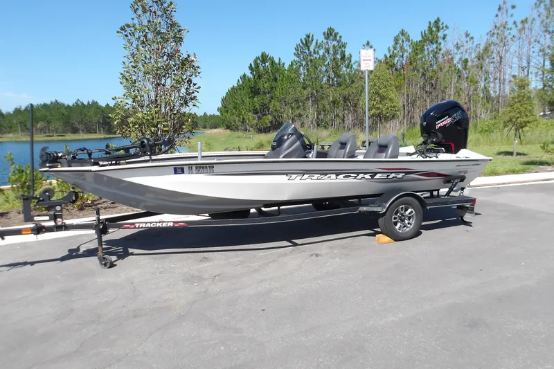 The Image of 2022 Tracker Pro Team 190 TX Tournament Edition boat on trailer by a lake. - 0