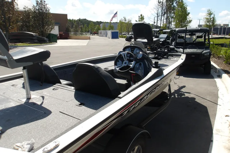 Slide: The Image of 2022 Tracker Pro Team 190 TX Tournament Edition boat parked outdoors, showcasing interior and steering wheel. - 5