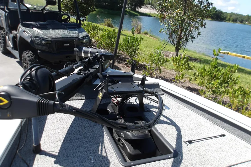 Slide: The Image of 2022 Tracker Pro Team 190 TX Tournament Edition boat near a lake with off-road vehicle. - 7