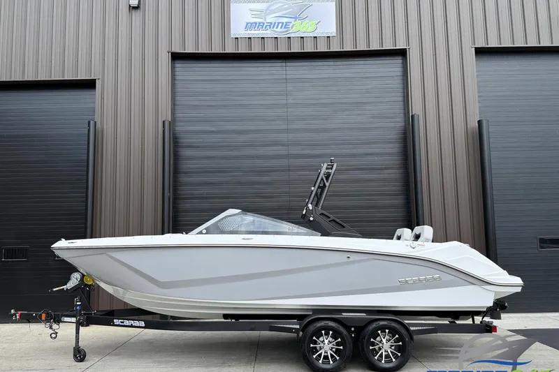 Slide: The Image of 2026 Scarab 235 SE boat on trailer, parked outside a building. - 0