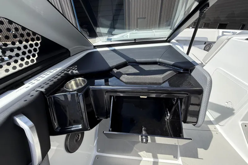 Slide: The Image of 2026 Scarab 235 SE boat interior with storage compartment and cup holder. - 19